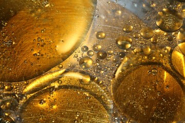 Close-up of water mixed with orange oil in a bowl and bubbles are formed
