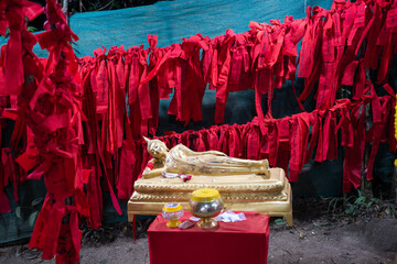 Golden Buddha statue and red cloth at Buddha's footprint and giant rocks at Khao Khitchakut National Park, Chanthaburi, Thailand.