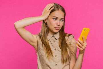 Woman use mobile phone smartphone typing browsing, loses becoming surprised sudden lottery results, bad fortune, loss, fail. Pretty blonde girl isolated alone on pink studio background, indoors