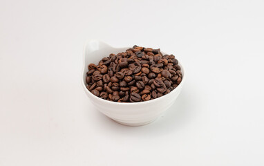 Coffee beans are poured into a ceramic bowl