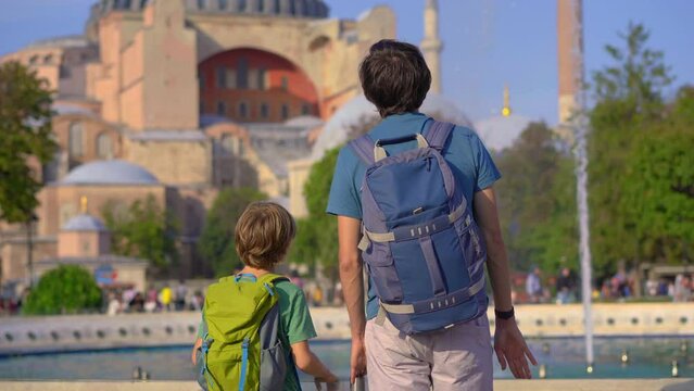 Father and son backpackers admire the grandeur of Aya Sophia, soaking in the ancient beauty of Istanbul's skyline, their joyful bond over the shared love of travel emanating amidst the historical