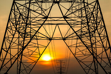 Silhouette of electricity transmission pylon during sunset time, summer evening.