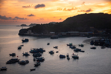 Sea bay in Vietnam with many fishing boats on sunset. View from above