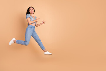 Fototapeta na wymiar Photo of charming positive funny woman wear blue trendy clothes introduce empty space isolated on beige color background