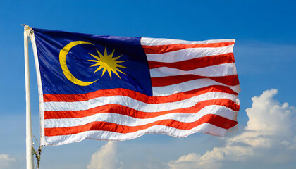 Die Fahne von Malaysia, flattert im Wind, isoliert, gegen den blauen Himmel