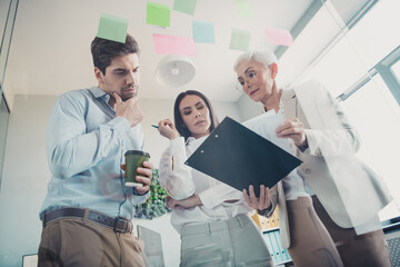Photo of business people working on company marketing report thinking in workstation