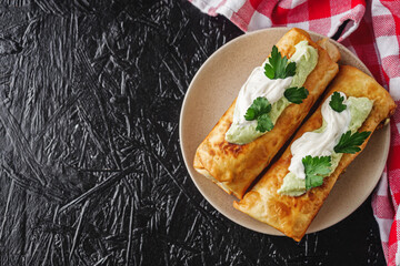set of delicious fresh colorful deep-fried chimichanga on a dark background