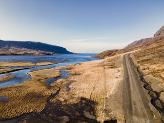 Empty dirt road across in the fjord