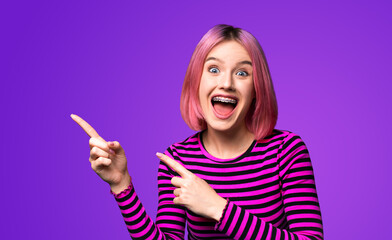 Excited very happy pink woman in braces, opened mouth, wear red striped jumper sweater advertise pointing area for sales slogan text, isolated violet purple background. Dental care ad advertisement.