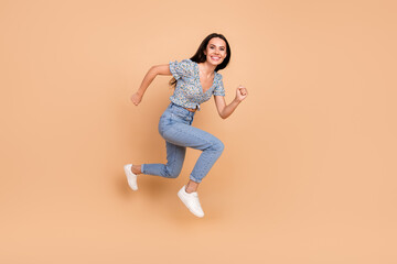 Fototapeta na wymiar Photo of funky carefree cheerful woman wear blue trendy clothes run fast empty space isolated on beige color background