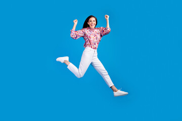 Fototapeta na wymiar Full length photo of lucky funky lady dressed print blouse jumping high having fun isolated blue color background