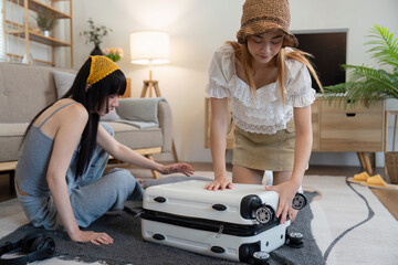 Friendship. Travel together. Two asian young woman friends packing for summer vocation. preparation planning concept