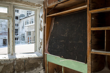 An old blackboard in a classroom at an abandoned school in the Arctic. Snow outside the broken window. Devastation in the Far North of Russia. Problems with the education system in the Russian regions - 794082264