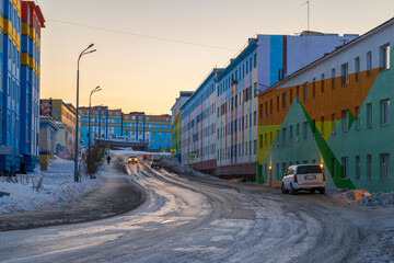 View of the street and colorful multi-colored buildings in a well-maintained northern city. Travel to the Arctic and the Russian Far East. Anadyr city, Chukotka, Russia. Evening city landscape. - 794083893