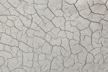 The cracked ground, soil texture and dry mud.