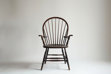 sophisticated photograph highlighting the sophistication of a Windsor chair in a contemporary context, showcased against a white background, accentuating its graceful silhouette an
