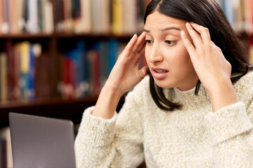 University, laptop or woman with stress headache at campus library for research, planning or homework assignment. College, pressure or student frustrated by exam deadline, anxiety or pc glitch or 404