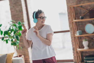 Photo of nice senior woman dance headphones music dressed white clothes cozy living room home house flat indoors pension concept