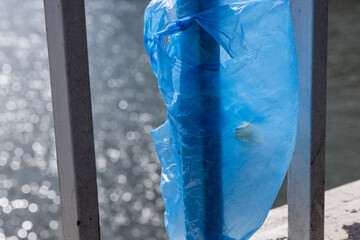 Blue Plastic bag hanging on the railing of Elisabeth bridge over Donau river in Budapest. Garbage...
