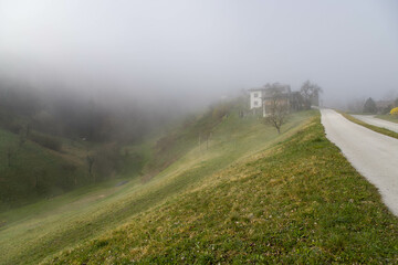 Foggy landscape in the early morning. Green mountains covered with thick fog
