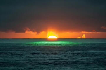 Naklejka na ściany i meble Green flash at sunset, a fleeting meteorological event on the ocean's horizon