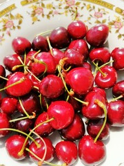 Juicy red cherries lie on a beautiful plate