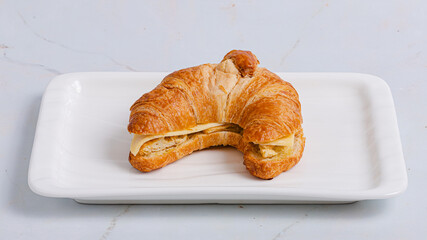 Croissant sandwich on plate isolated on white