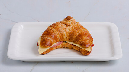 Croissant sandwich on plate isolated on white