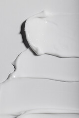 Vertical image of whate soft creme texture, swatches on bright background