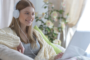 young beautiful woman in headphone with laptop