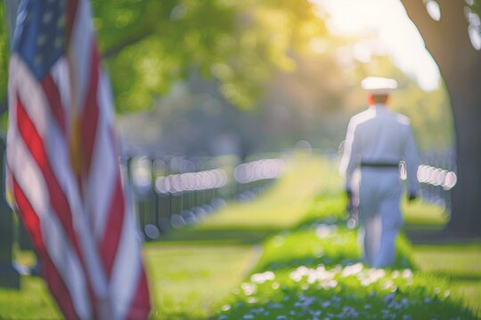 Blurred American flag with a uniformed officer in cemetery; soft focus, serene backlight, patriotic theme.