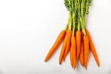 Carrots on a textured wooden background. Fresh and sweet organic carrots on a white background. Carrot slices. Vegan. Ingredients for salad. Place for text. Copy space. Flatley