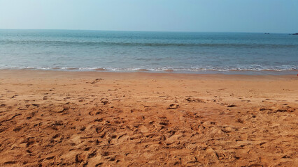 Beach view with blue sky and water and brown texture sand