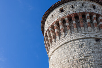 The historical Torre dei Prigionieri in Brescia castle, captured in bright daylight, showcases its...
