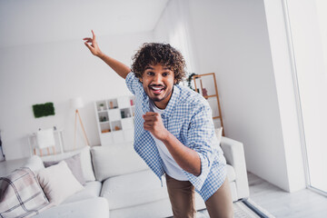 Photo of handsome cheerful guy dressed plaid shirt enjoying weekend singing dancing indoors room...