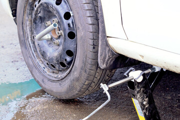 the car is lifted on a pneumatic jack for wheel repair
