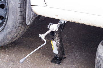 the car is lifted on a pneumatic jack for wheel repair

