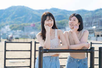 砂浜を歩く2人の若い女性