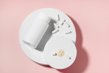 Mockup of white capsule pill jar and shell with active ingredient on pedestal on pink isolated background. Concept of health, medicine, pharmacy and dietary supplements