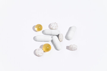 Different colors of capsules, antibiotics and pills on a white isolated background. Concert of pharmacy, health, treatment of diseases. Background for your design