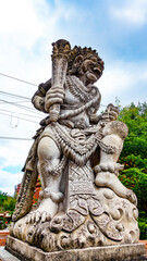 Fototapeta na wymiar BALI APRIL 2024 - Traditional guard demon statue carved in stone on Bali island, Indonesia