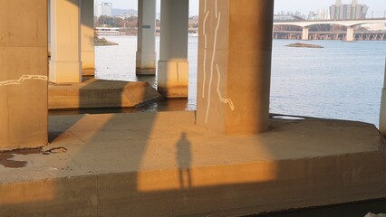 The shadow of a man under the Han River Bridge