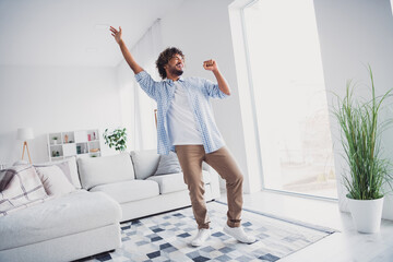 Photo of cheerful positive guy dressed plaid shirt dancing singing mic enjoying weekend indoors...