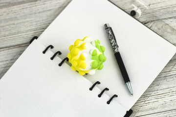 Notepad diary with pen and anti-stress ball on the desktop
