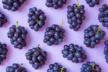 Foto op Aluminium Fresh juicy grapes on a vibrant purple background, arranged in a top view flat lay style display © SHOTPRIME STUDIO