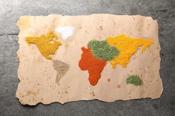 World map of different spices on grey table, top view