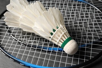 Feather badminton shuttlecocks and rackets on grey background, closeup