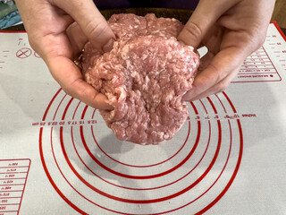 close-up of a woman's hand kneading fresh minced meat for meatballs or hamburger