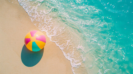 Fototapeta na wymiar Aerial view of a beach with clear waters and a vibrant beach ball on sand