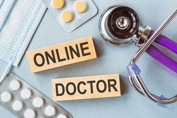 Online Doctor Consultation Concept Displayed With Wooden Blocks, Stethoscope, and Medication on a...